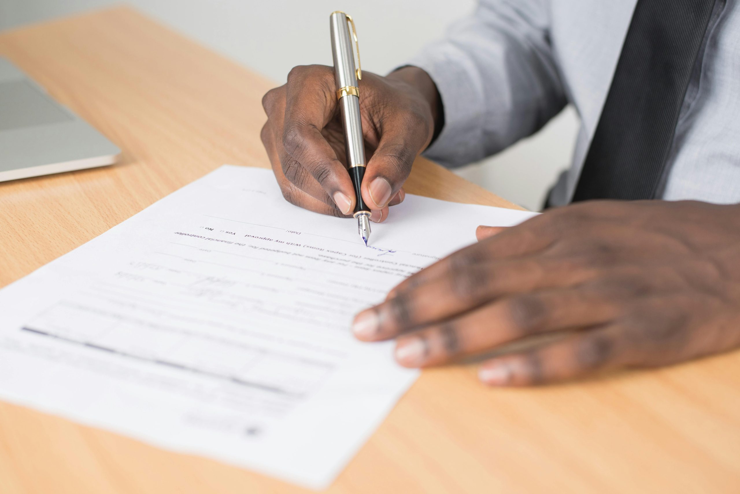 Photo of a person signing a contract.