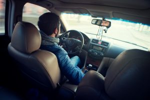 A man sitting in a parked car.