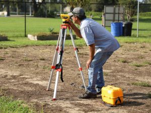 Professional surveyor looking through a piece of surveying equipment.
