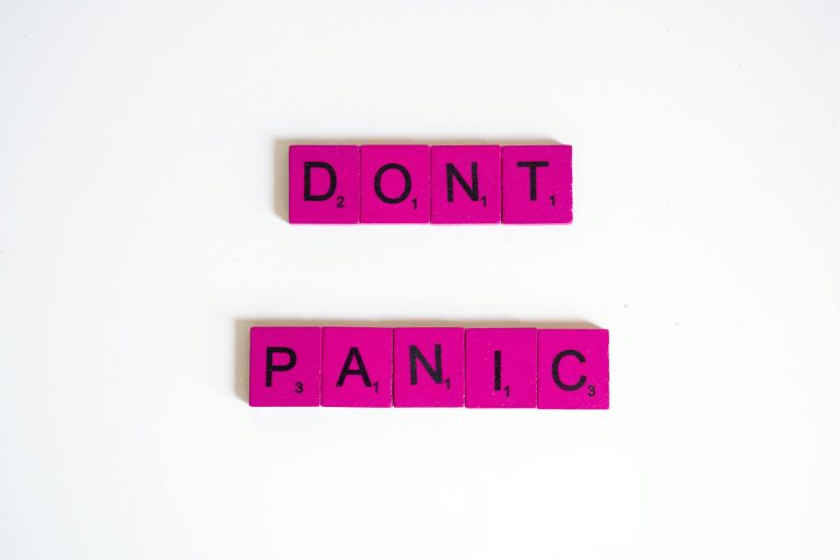 Bright pink letter tiles spelling out "DON'T PANIC" arranged on a white background, visually reinforcing a message of calm for condo sellers who may be worried about their listing price.
