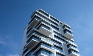 Modern condominium building under a clear blue sky, symbolizing the importance of a well-maintained and financially prepared condo association through a reserve study