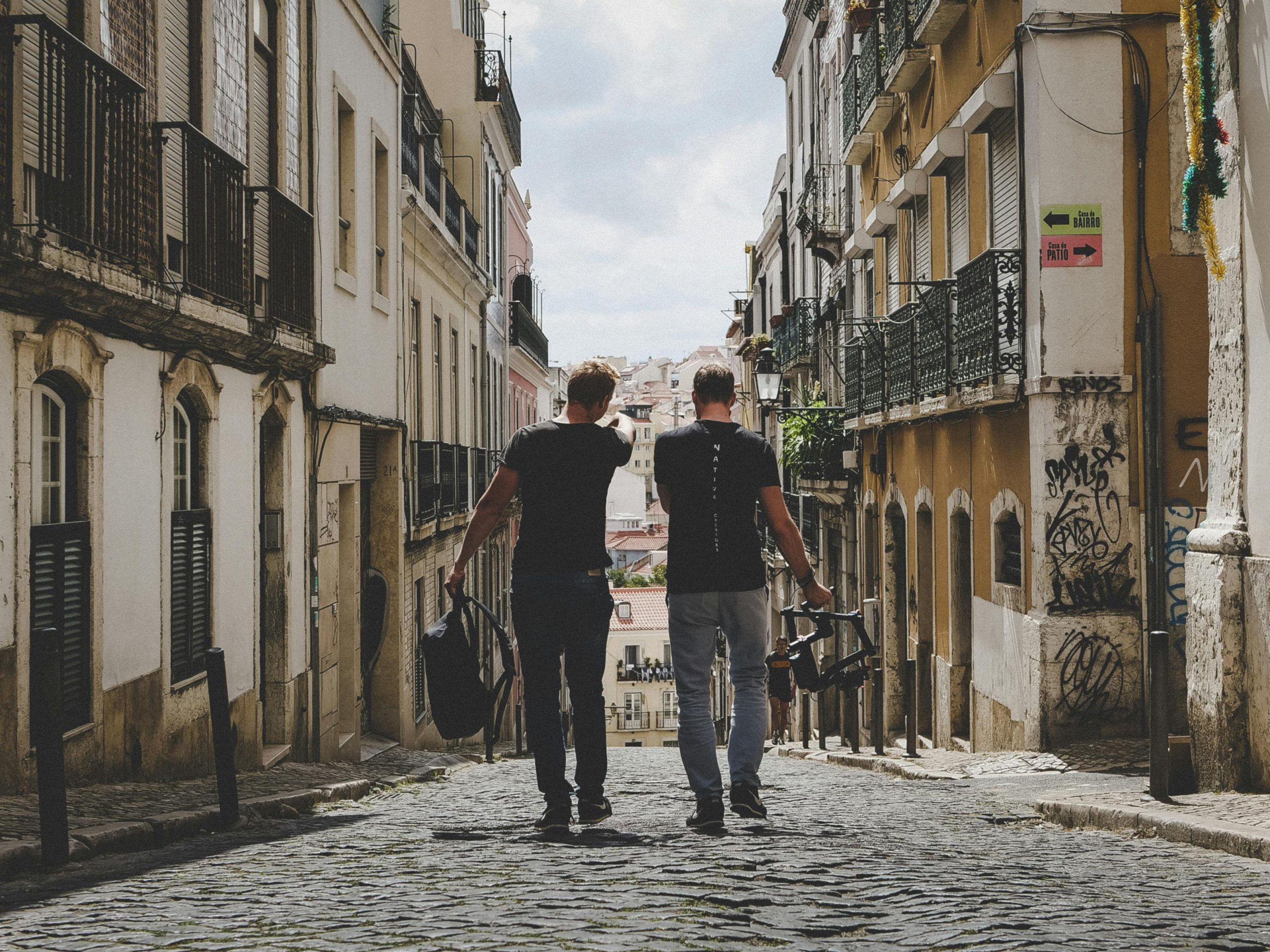 - Unbiased Real Estate Advice: The Truth About Real Estate Two friends walking down a cobblestone street together, symbolizing partnership and the journey of buying a home with a friend.