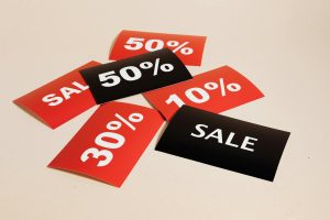 Assorted sale and discount cards showing percentages, symbolizing contracts, agreements, and the choices buyers and sellers face in real estate.