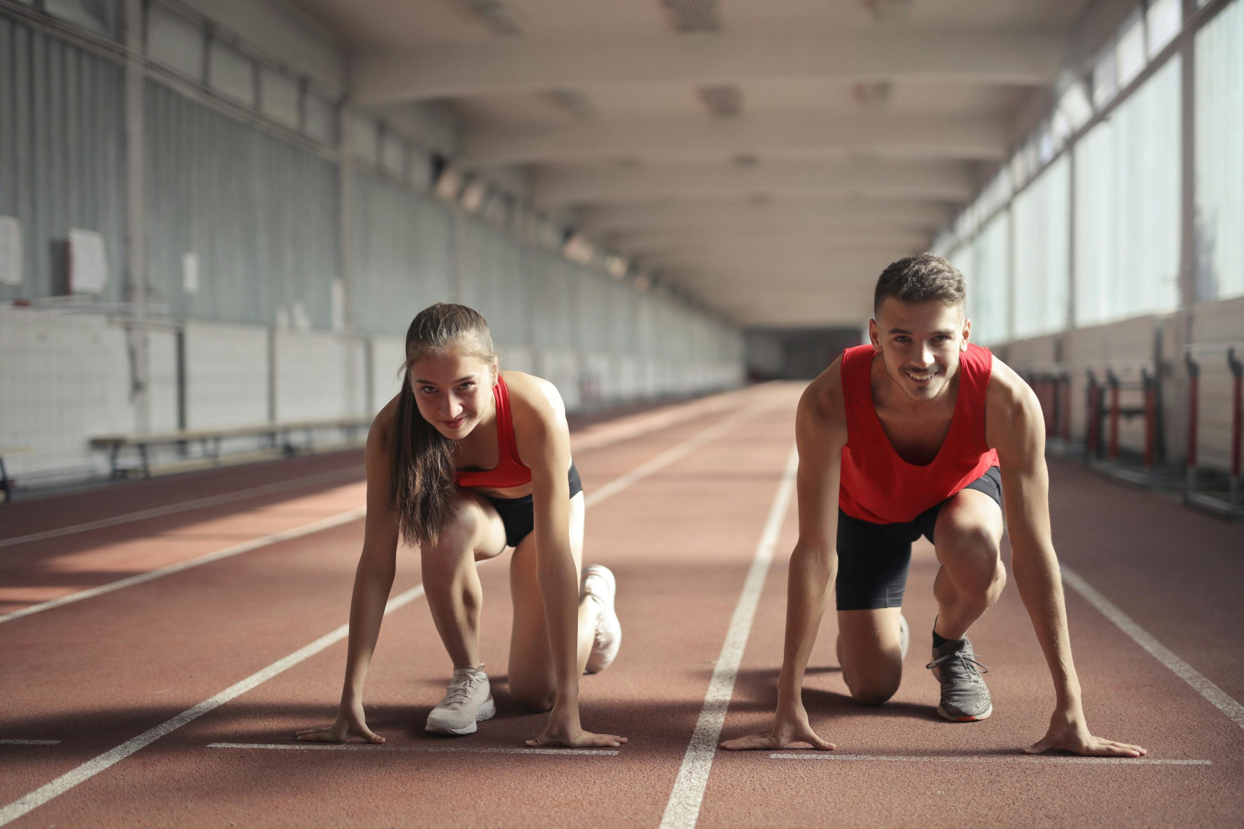 Two athletes at the starting line of a track race, symbolizing competition and the need to verify offers in an escalation clause.