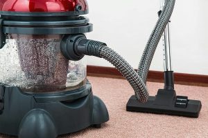 Close-up of a vacuum cleaner on carpet, representing the importance of new carpet and clean flooring when preparing a home for sale.