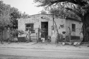 Old neglected house with cracked walls and a damaged fence, representing the challenges of dealing with an inherited home in poor condition.