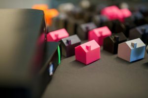 Colorful small house models arranged on a table symbolizing a balanced and normal housing market.