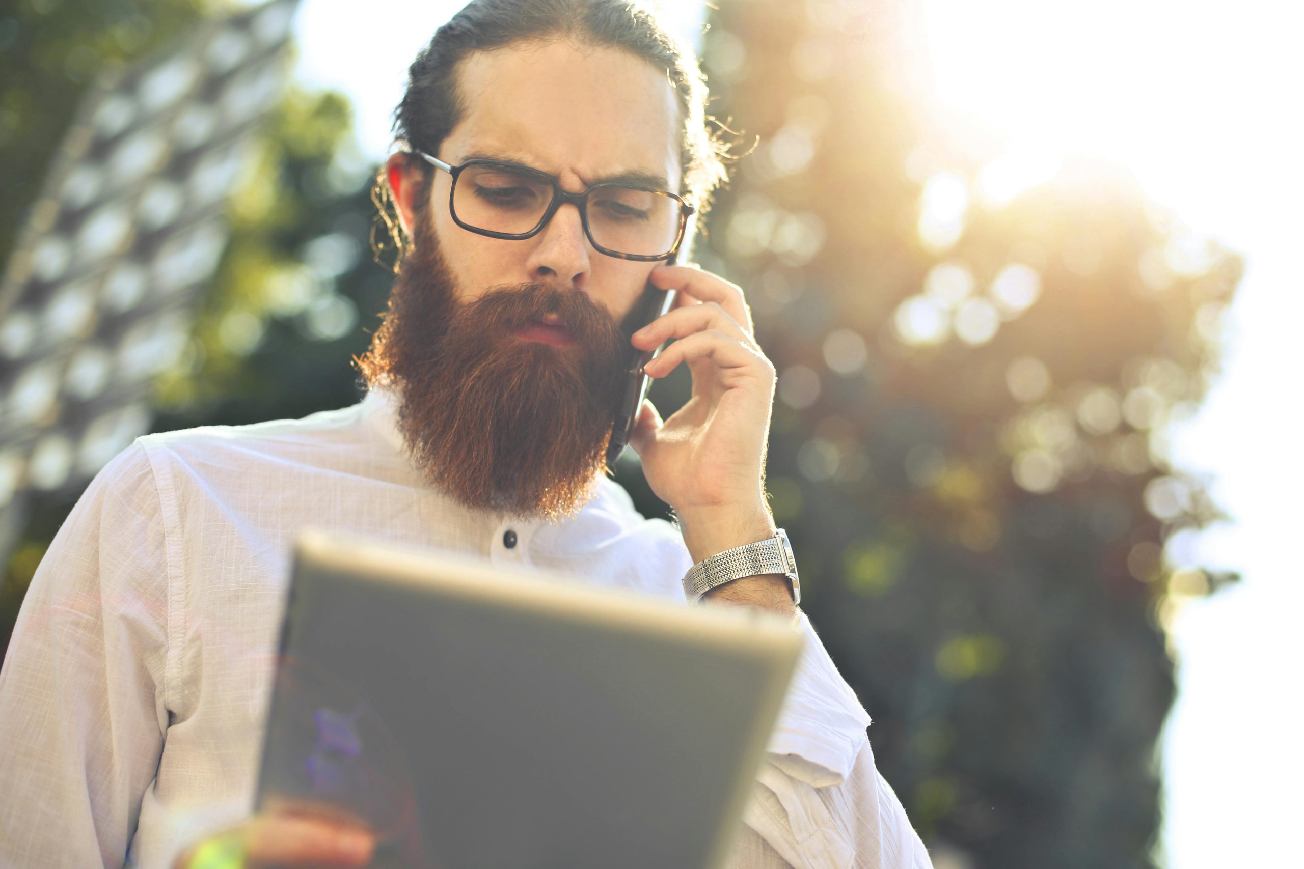 - Unbiased Real Estate Advice: The Truth About Real Estate Bearded homeowner on the phone checking a tablet in bright sunlight after discovering home showing requests went to the junk folder.