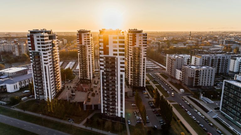 Aerial view of modern apartment towers at sunset showing dense rental housing in an urban neighborhood.